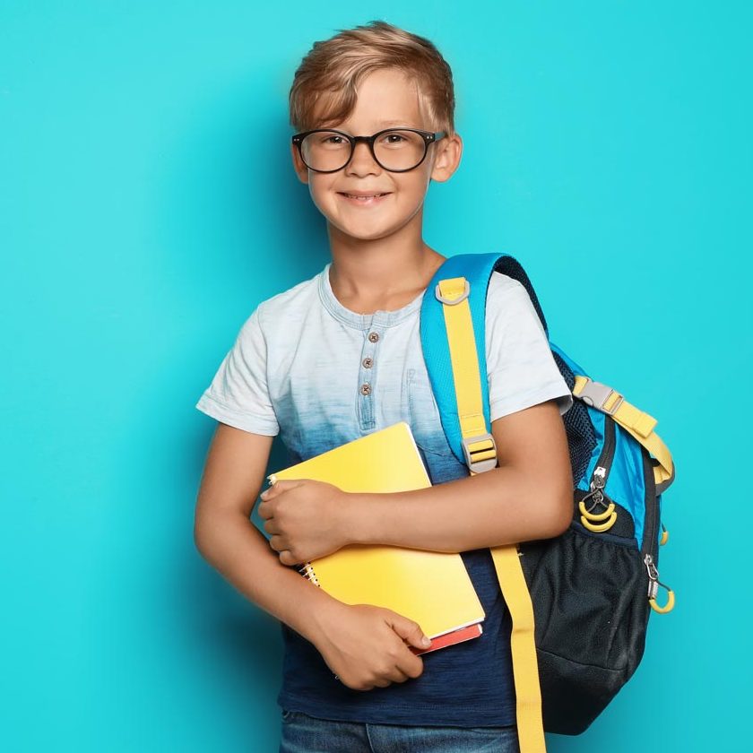 A schoolboy wearing glasses and carrying a backpack on a blue background.