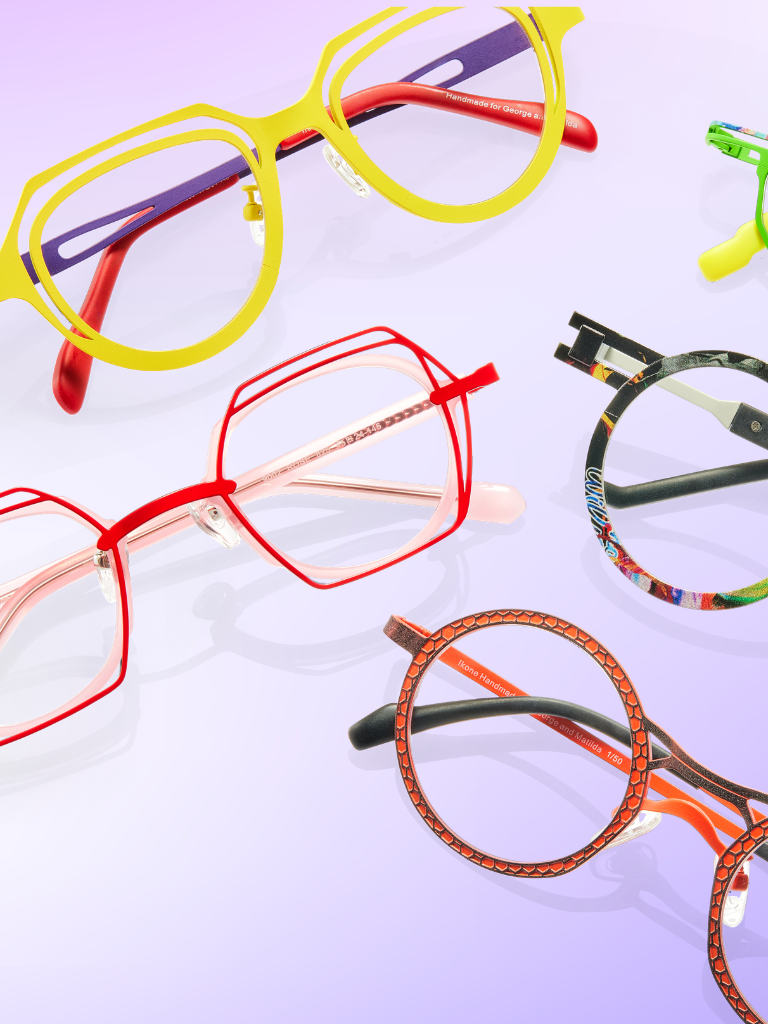 Five pairs of colorful, uniquely shaped eyeglasses are arranged on a light purple background.